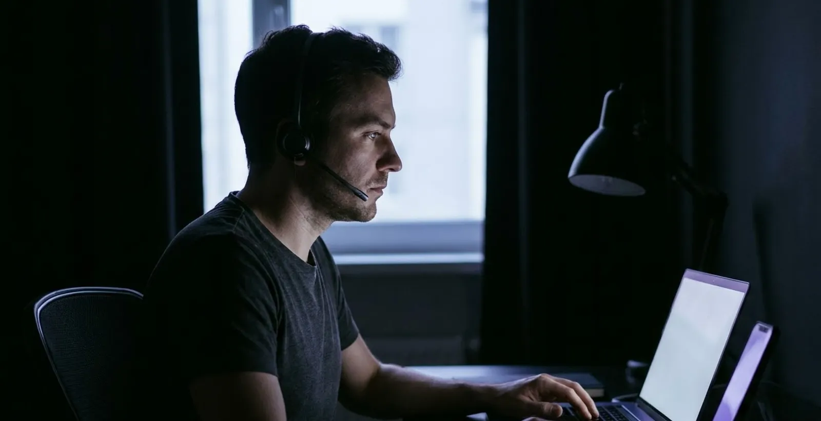 An agent working at a laptop in a quiet room